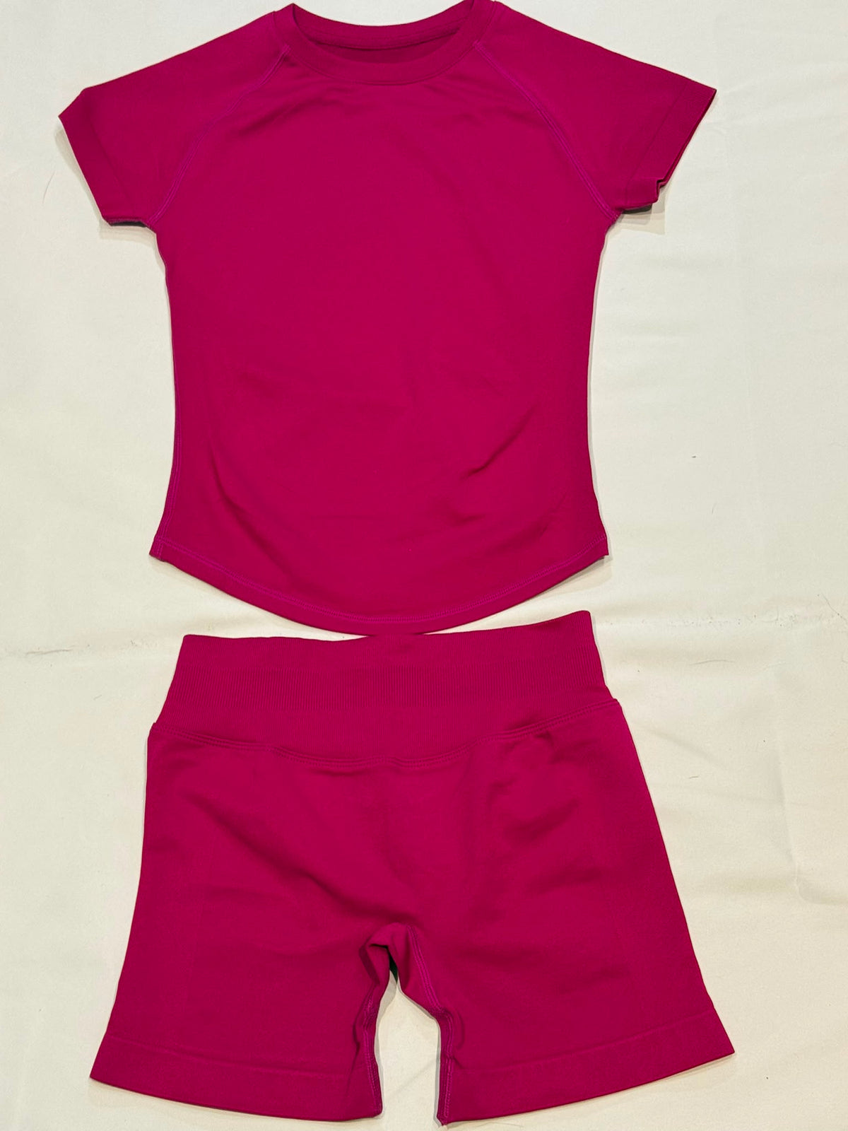 Pearl, Berry Red, Ladies Gym set. Short-sleeve top and matching high-waisted shorts with scrunch bum, laid flat.